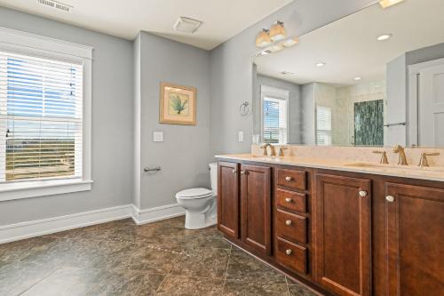 a bathroom with a double sink and a toilet at Cape Point Retreat 7 Bedroom Home by KEES Vacations in Buxton
