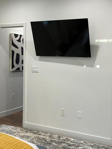 a flat screen tv hanging on a white wall at The Verna Mae in Los Angeles