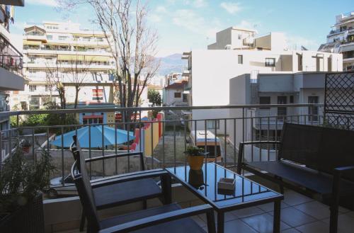 balcón con mesa y vistas a la piscina en Happy Place Home # 1, en Volos