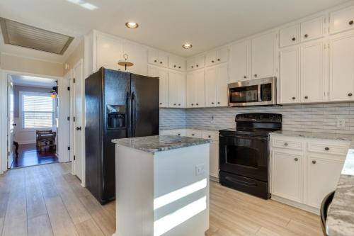 a kitchen with white cabinets and a black refrigerator at On-Site Lake Access and Fire Pit Bonham Home! in Bonham