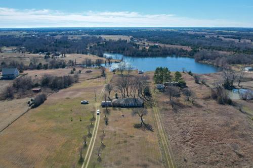 an aerial view of a field and a lake at On-Site Lake Access and Fire Pit Bonham Home! in Bonham