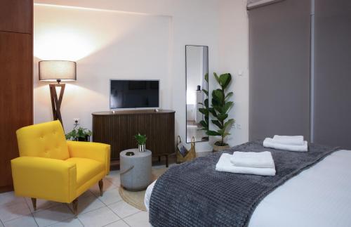 a bedroom with a bed and a yellow chair at Happy Place Home # 1 in Volos