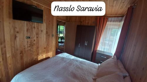 a bedroom with a bed with a tv on the wall at CASA DE CAMPO in Villarrica