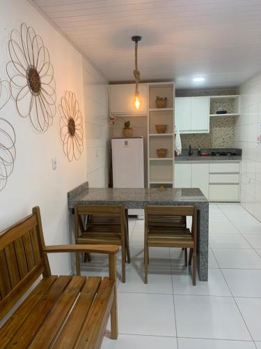 cocina con mesa, sillas y nevera en Residencial Morro de São Paulo Casa Amarela, en Morro de São Paulo