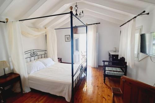 een slaapkamer met een hemelbed en een piano bij Villa Kochili. in Symi