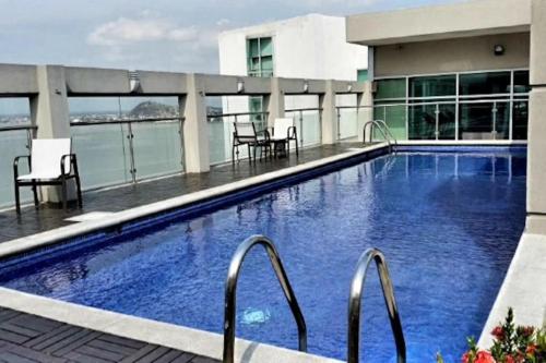a large swimming pool on the roof of a building at Ecusuites Ejecutiva Mini view río guayas Aeropuerto in Guayaquil