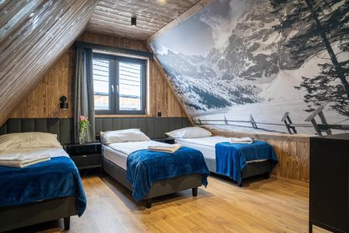 2 camas en una habitación con un cuadro en la pared en TATRZAŃSKIE TARASY Luxury Chalets, en Małe Ciche