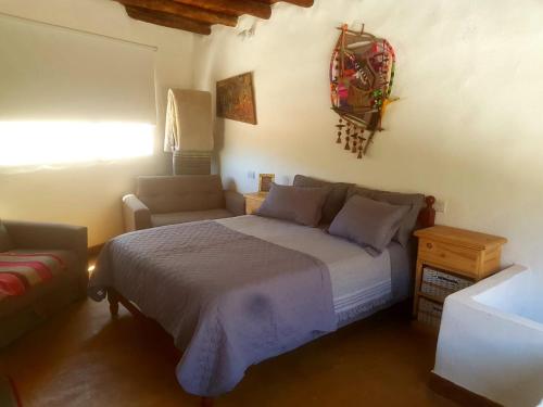 a bedroom with a large bed and a couch at Cabañas Paqa Paqa in Maimará