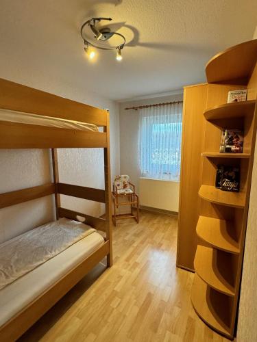 a bedroom with two bunk beds and a window at Ferienhaus Eichhölzle in Münsingen