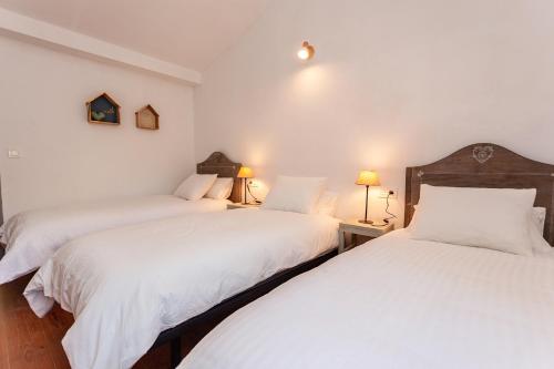 two twin beds in a room with white walls at Caserío El Ronzón in Camoca de Abajo