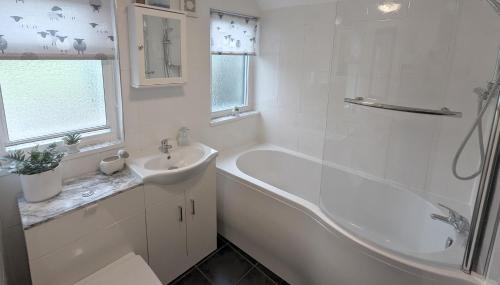 a white bathroom with a tub and a sink at The Casey in Fenny Bentley