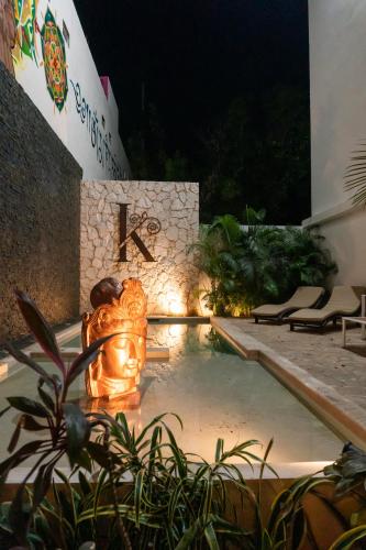 a pool with a statue in front of a building at Kanté Hotel - Downtown Tulum in Tulum