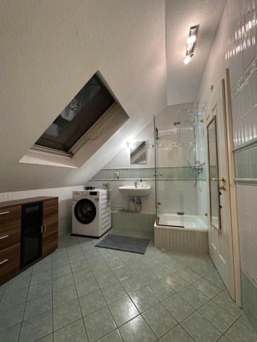 a bathroom with a shower and a sink and a washing machine at Parkplätze, Einzelbetten, 2 Balkone, fast Wi-Fi 100 Mbit, Homeoffice, Aufzug, lichtdurchflutet, Panoramablick in Erlensee