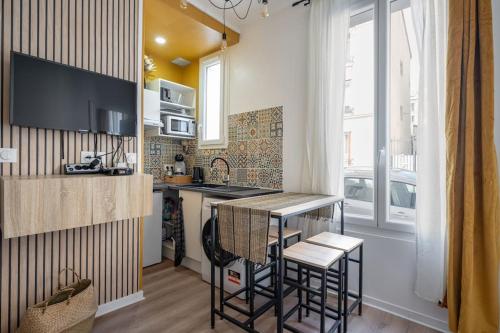 une cuisine avec un comptoir et des tabourets dans une pièce dans l'établissement TinyÉbène*Paris/Stade de France, à Saint-Denis