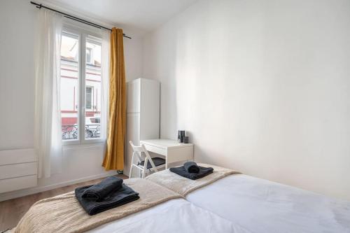 une chambre blanche avec un lit et un bureau dans l'établissement TinyÉbène*Paris/Stade de France, à Saint-Denis