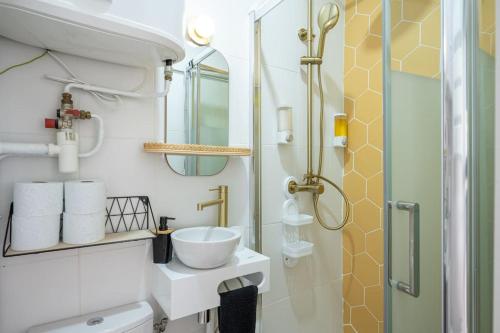 une salle de bain avec un lavabo et une douche dans l'établissement TinyÉbène*Paris/Stade de France, à Saint-Denis