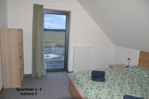a bedroom with a bed and a large window at Apartmány Benátky in Suchdol nad Lužnicí