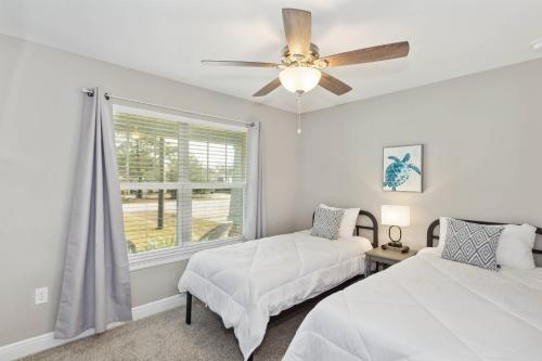 a bedroom with two beds and a ceiling fan at 1977 Esplanade St in Navarre