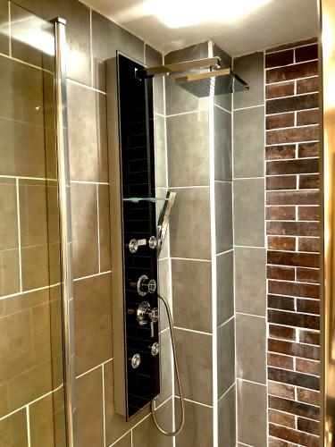 a shower with a glass door in a bathroom at Les Loges Du Théatre 160m2 PRIVÉ 14 personnes MAX tout équipé a 200m de l'AVENUE DE CHAMPAGNE et toutes commodités DEGUSTATION CHAMPAGNE OFFERTE jacuzzi sauna jeux velos EMPLACEMENT EXCEPTIONNEL et CHIC in Épernay