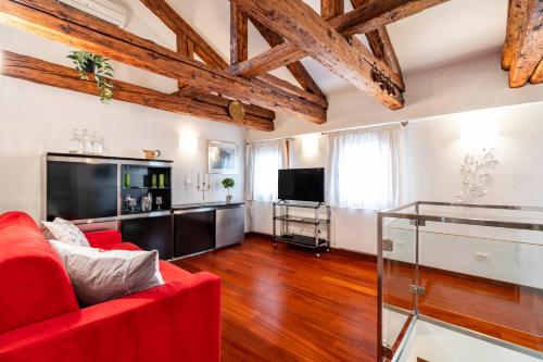 sala de estar con sofá rojo y TV en Glass House - Loft 2 minutes to Rialto Bridge & View, en Venecia