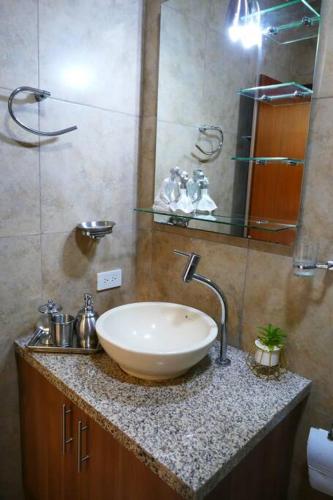 a bathroom with a sink and a mirror at Ecusuites Penthouse Vía Costa Ceibos Puerto Azul in Guayaquil