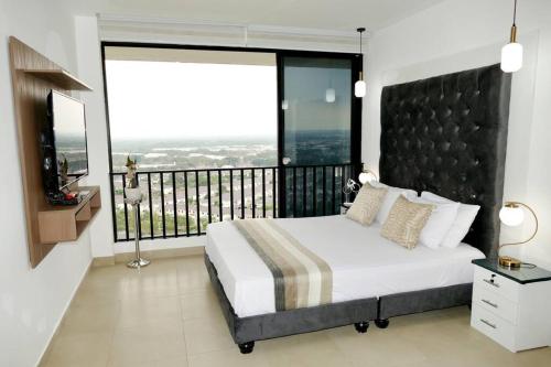um quarto com uma cama grande e uma varanda em Ecusuites Penthouse Vía Costa Ceibos Puerto Azul em Guayaquil