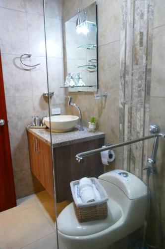 a bathroom with a toilet and a sink at Ecusuites Penthouse Vía Costa Ceibos Puerto Azul in Guayaquil