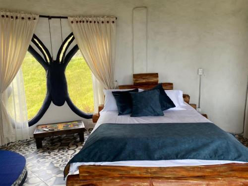 a bedroom with a bed and a large window at Cabaña Malaquita Suite - Hotel Seilan Alojamiento Rural in Paipa