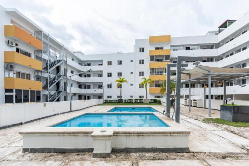 uma piscina em frente a um edifício de apartamentos em Precioso Apartamento con terraza y Jacuzzi privado em Jacagua