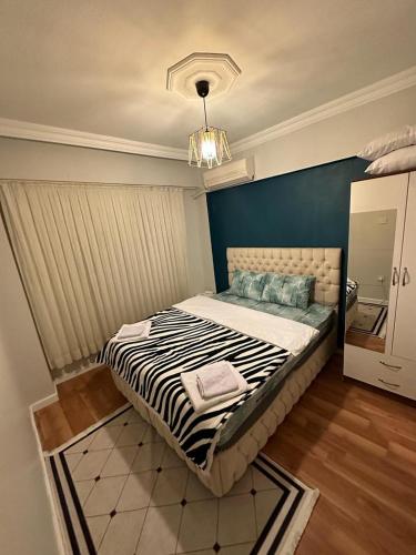 a bedroom with a large bed with a blue wall at Kadıköy Holiday Home in Istanbul
