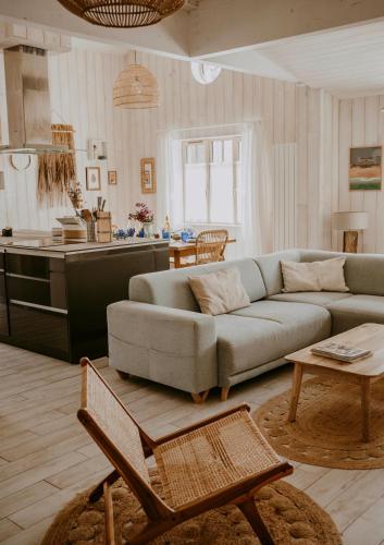 un salon avec un canapé et une cuisine dans l'établissement Sam Suffit Beach Houses 2 Maisons 6 chambres 14 pers 150 m de la plage, à Biscarrosse-Plage