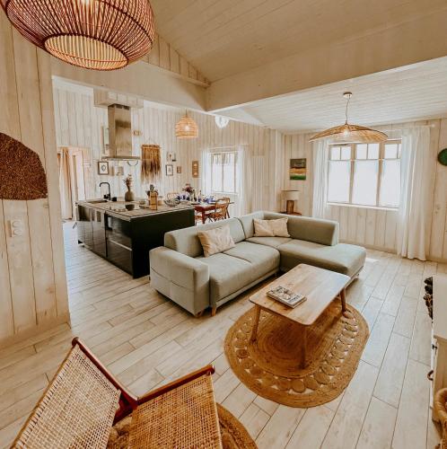 un salon avec un canapé et une table dans l'établissement Sam Suffit Beach Houses 2 Maisons 6 chambres 14 pers 150 m de la plage, à Biscarrosse-Plage