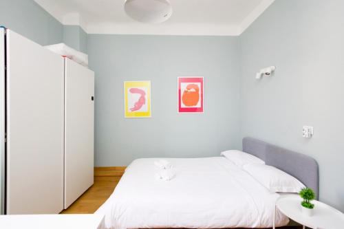 een witte slaapkamer met een bed en een tafel bij Minimal Design in Milano in Milaan