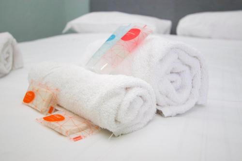 een stapel handdoeken bovenop een bed bij Minimal Design in Milano in Milaan