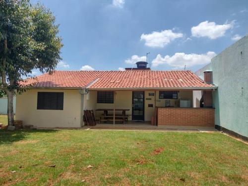 una casa con techo rojo y patio en Casinha Charmosa & Rústica, en Indaiatuba