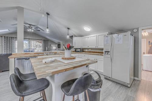 a kitchen with a counter with chairs and a refrigerator at Ruidoso Retreat with Mtn Views about 20 Mi to Ski Apache in Ruidoso