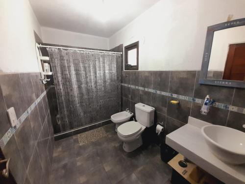 uma casa de banho com um WC, um chuveiro e um lavatório. em Casa de la Montaña em Villa Parque Síquiman