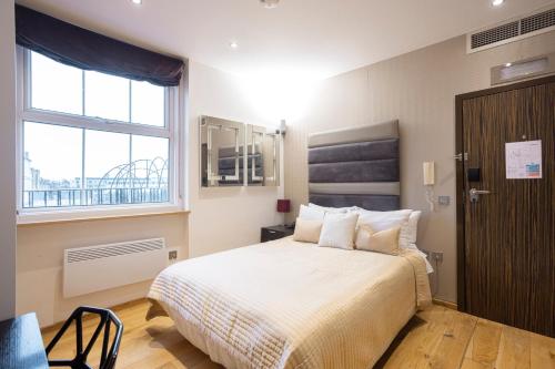 sypialnia z dużym łóżkiem i oknem w obiekcie Space ApartHotel w Londynie