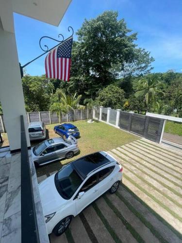 two cars parked in a yard with an american flag at Rancho Hope in San Rafael Norte