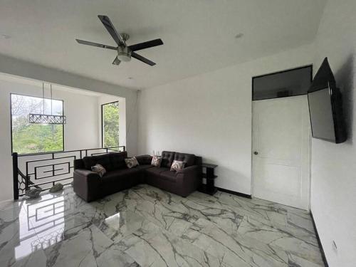 a living room with a couch and a ceiling fan at Rancho Hope in San Rafael Norte