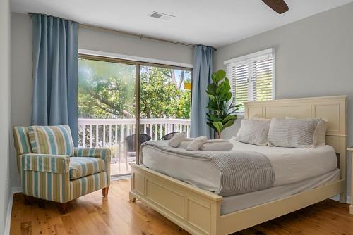 a bedroom with a bed and a chair and a window at Lagoon Villa Condo in Isle of Palms