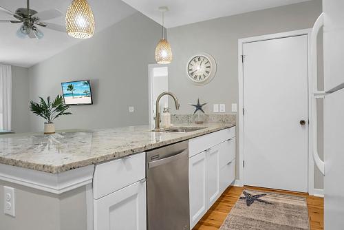 a kitchen with a sink and a clock on the wall at Lagoon Villa Condo in Isle of Palms
