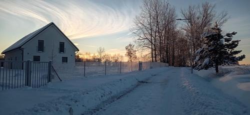 a snow covered road in front of a white house at Apartmány Benátky in Suchdol nad Lužnicí