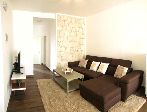 a living room with a brown couch and a table at Happy Place, Boa Vista, Salrei in Sal Rei