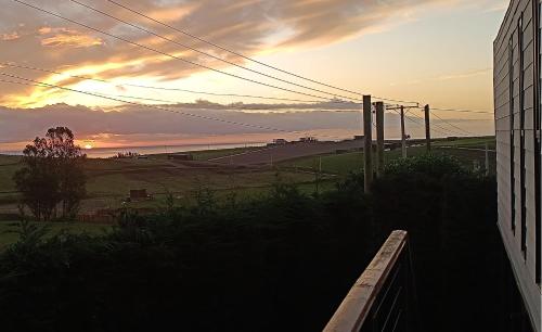 a sunset view of a field with a building at Parcela PLANA con Casa Vista al Mar y Valle, WIFI, TV CABLE, UBICACIÓN PRIVILEGIADA, Portón Automático, PRIVADA in Matanzas
