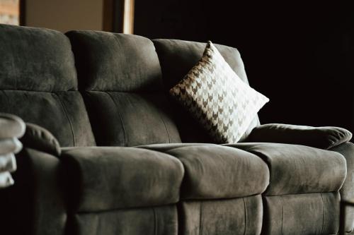 a brown leather couch with a pillow on it at Private Spa Lodge Odenwald in Lindenfels