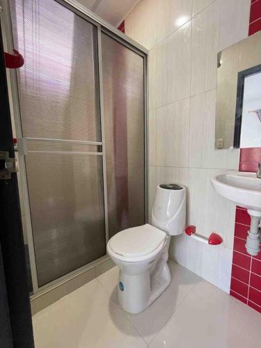 a bathroom with a shower and a toilet and a sink at Rio-ApartaHotel-Lagos in Leticia