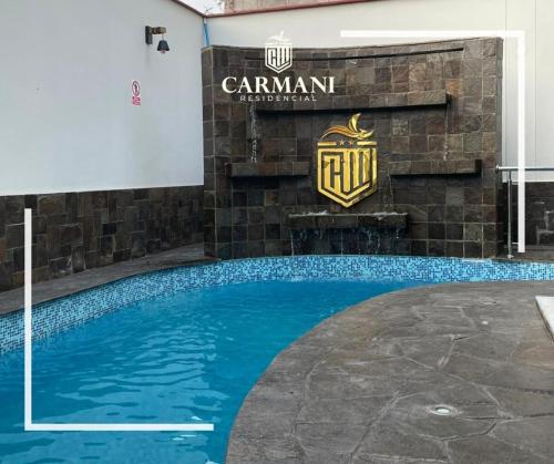 une piscine avec un panneau sur un bâtiment dans l'établissement RESIDENCIAL CARMANI, à Tacna