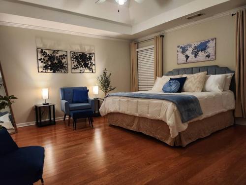 a bedroom with a large bed and a blue chair at 2,298Sqft-King Bed-BBQ-Gbps-W/D in Snellville