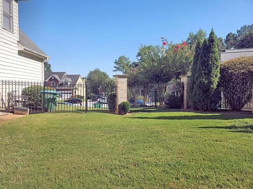 a fence in a yard next to a house at 2,298Sqft-King Bed-BBQ-Gbps-W/D in Snellville